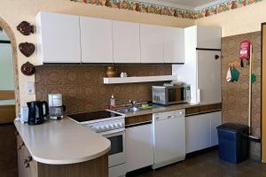 a kitchen with white cabinets and a microwave at Apartment Wurth in Groß-Siegharts