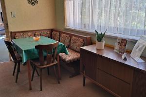 a dining room with a table and a couch at Apartment Wurth in Groß-Siegharts +4 photos