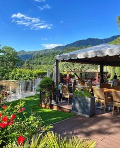 a patio with a table and chairs and mountains in the background at HOTEL ST SEBASTIEN in Roquebillière