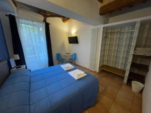 a bedroom with a blue bed and a window at Porta Mazzini Affittacamere in Iesi