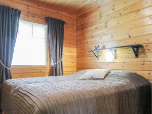 a bedroom with a bed in a wooden room at Holiday Home Artturi by Interhome in Levi