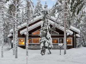 a log cabin in the woods in the snow at Holiday Home Artturi by Interhome in Levi