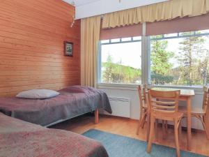 a bedroom with a bed and a table and a window at Holiday Home Moitakuru a5 by Interhome in Saariselka +10 photos
