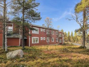 a red house with a rock in front of it at Holiday Home Moitakuru a5 by Interhome in Saariselka