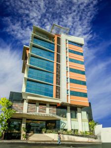 una mujer caminando delante de un edificio alto en Kew Hotel Tagbilaran en Tagbilaran City