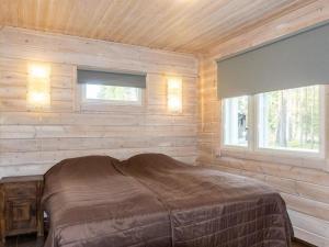 a bedroom with a bed in a wooden wall at Holiday Home Atrin suvanto a by Interhome in Levi