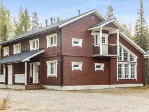 a large wooden house with white windows at Holiday Home Atrin suvanto a by Interhome in Levi
