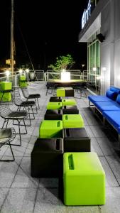 a row of tables and chairs on a patio at night at Aloft by Marriott Chapel Hill in Chapel Hill