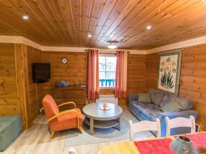 a living room with a couch and a table at Holiday Home Suvantovirta by Interhome in Kaukonen