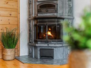 a stone fireplace in a living room with a fire at Holiday Home Ojala by Interhome in Virta