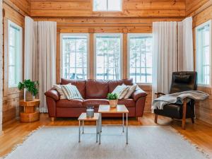 a living room with a brown couch and a table at Holiday Home Ojala by Interhome in Virta