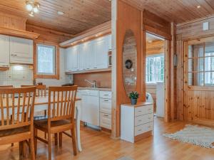 a kitchen with white cabinets and a table and chairs at Holiday Home Ojala by Interhome in Virta +42 photos