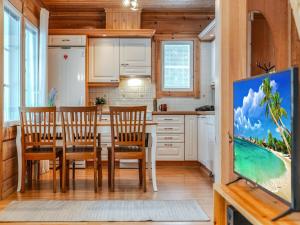 a kitchen with a table and chairs and a tv at Holiday Home Ojala by Interhome in Virta
