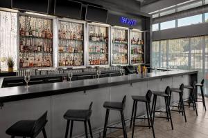 a bar with black stools in a room at Aloft by Marriott Chapel Hill in Chapel Hill