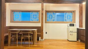 a kitchen with a table and chairs and windows at Hanok Hyeyum in Jeonju