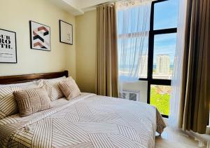 a bedroom with a bed and a large window at The Asher Mactan at Mactan Plains Residences in Mactan +39 photos