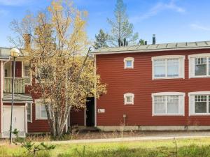 a red house with a tree in front of it at Holiday Home Moitakuru a14 by Interhome in Saariselka