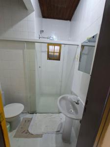 a white bathroom with a sink and a toilet at CASA DE HOSPEDAGEM FLORES PARATY AMBIENTE FAMILIAR 600M do CENTRO in Paraty