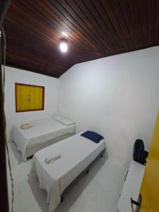 two beds in a room with a wooden ceiling at CASA DE HOSPEDAGEM FLORES PARATY AMBIENTE FAMILIAR 600M do CENTRO in Paraty +5 photos