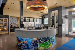 a lobby with a reception counter in a building at Aloft by Marriott Chapel Hill in Chapel Hill