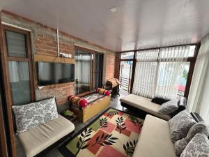 a living room with a couch and a brick wall at Bagaan Villa Homestay in Ilām +13 photos