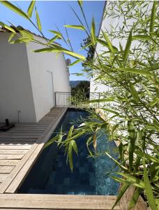 a swimming pool next to a building with plants at Villa Fautea Verdon in Sainte-Croix-de-Verdon