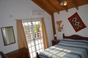 a bedroom with a bed and a large window at Cabañas Quilquelen in Merlo