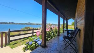 a porch of a house with a view of the water at Lodge playa pupelde, Ancud in Mecura