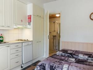 a kitchen with white cabinets and a bed in it at Holiday Home Levi star 1503 by Interhome in Levi