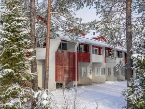 a house with a red deck in the snow at Holiday Home Moonlight 201 by Interhome in Levi