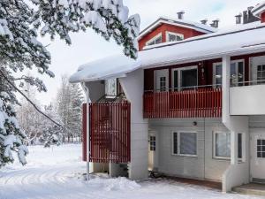 a house with a red gate in the snow at Holiday Home Moonlight 201 by Interhome in Levi +11 photos
