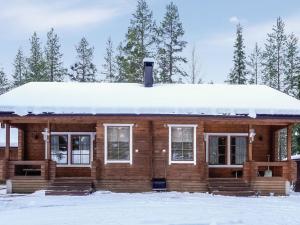 a log cabin with snow on the roof at Holiday Home Aslakit a by Interhome in Levi