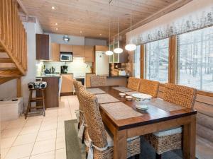 a kitchen and dining room with a wooden table and chairs at Holiday Home Aspilevi by Interhome in Levi