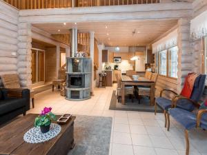 a living room with a fireplace in a log cabin at Holiday Home Aspilevi by Interhome in Levi