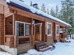 a log cabin in the snow with a front door at Holiday Home Aslakit a by Interhome in Levi
