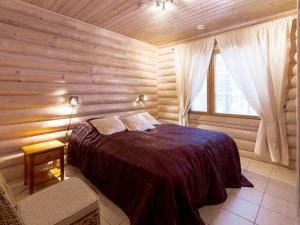 a bedroom with a bed in a wooden room at Holiday Home Aspilevi by Interhome in Levi +11 photos