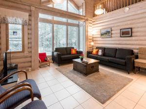 a living room with a couch and a table at Holiday Home Aspilevi by Interhome in Levi