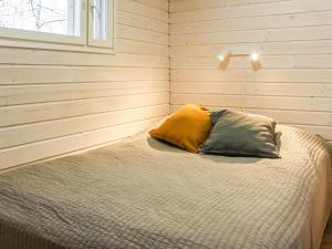 a bedroom with a bed with two pillows on it at Holiday Home Mukan maja by Interhome in Köngäs