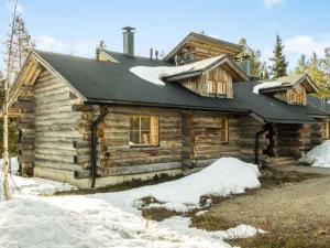 a log cabin with snow in front of it at Holiday Home Atokka by Interhome in Levi