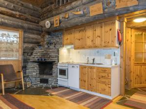 a kitchen with a stove and a stone fireplace at Holiday Home Atokka by Interhome in Levi +7 photos