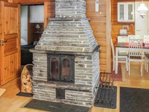 a brick fireplace in a living room with a table at Holiday Home Saikulevi by Interhome in Levi