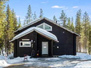 a small black cabin with a snow covered roof at Holiday Home Levijoutsen by Interhome in Levi