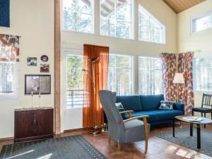 a living room with a blue couch and windows at Holiday Home Levijoutsen by Interhome in Levi +15 photos