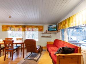 a living room with a red couch and a table at Holiday Home Jousimaja by Interhome in Ylläsjärvi