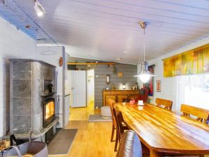 a dining room with a wooden table and a fireplace at Holiday Home Jousimaja by Interhome in Ylläsjärvi