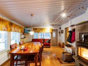a living room with a table and a fireplace at Holiday Home Jousimaja by Interhome in Ylläsjärvi