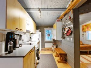 a kitchen with white appliances and a table in a room at Holiday Home Jousimaja by Interhome in Ylläsjärvi