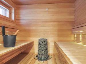 a small wooden sauna with a trash can in it at Holiday Home Karhu a by Interhome in Saariselka