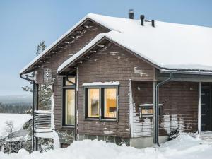 a small wooden house with snow on the roof at Holiday Home Karhu a by Interhome in Saariselka