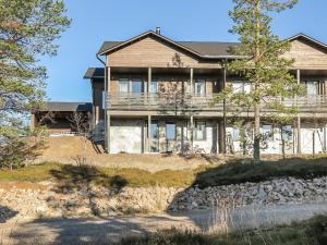 a house on a hill with trees in front of it at Holiday Home Karhu a by Interhome in Saariselka +19 photos